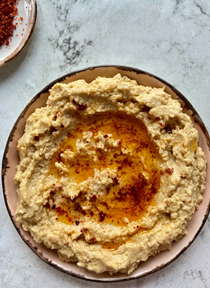 Warm hummus with red pepper flakes infused olive oil (Humus)