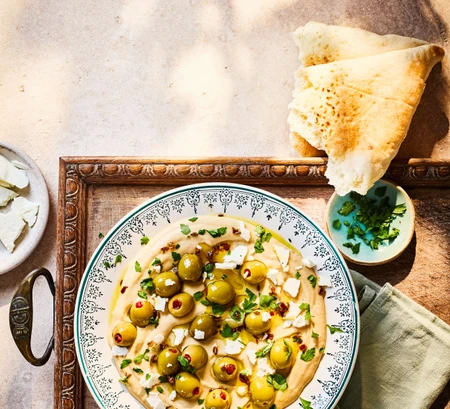 Warm olive-topped hummus