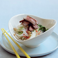 Warm rice noodle, beef and pak choi salad with toasted peanuts