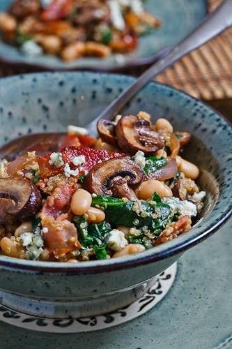 White bean and spinach quinoa salad with bacon, caramelized onions, mushrooms and blue cheese in a bacon pan sauce dressing