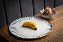 White chocolate banana filled with banana mousse and popping candy, a side of banana cake, caramel, banana ice cream and granola ('No ordinary schoolboy')