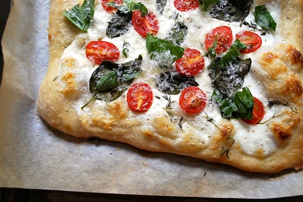 White pizza with ricotta, yogurt, tomatoes, and basil