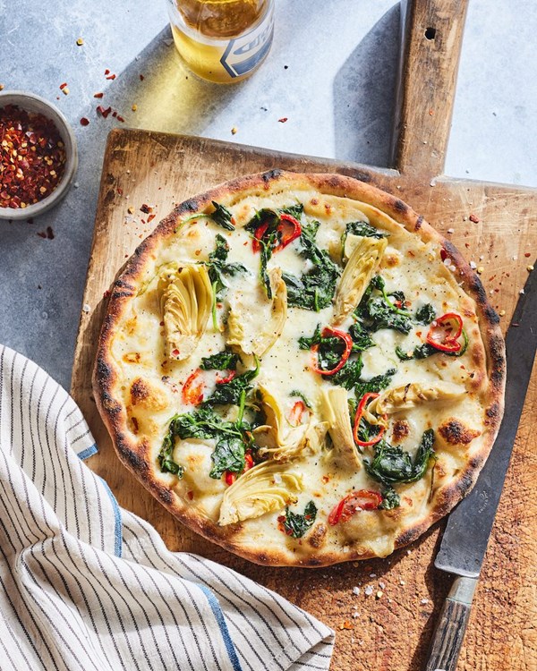 White pizza with spinach, red chili, and lemon