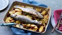 Whole baked fish with potatoes, lemon & sun-dried tomatoes