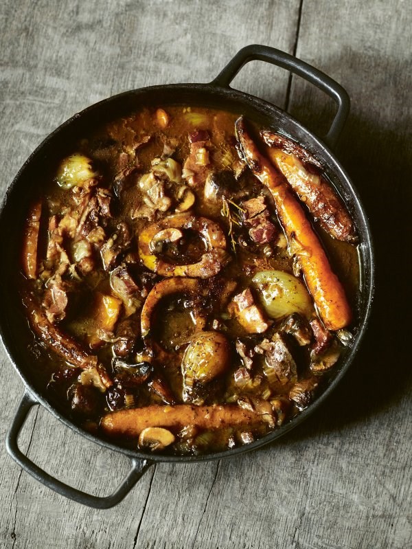 Whole beef shin with red wine, carrots and little onions