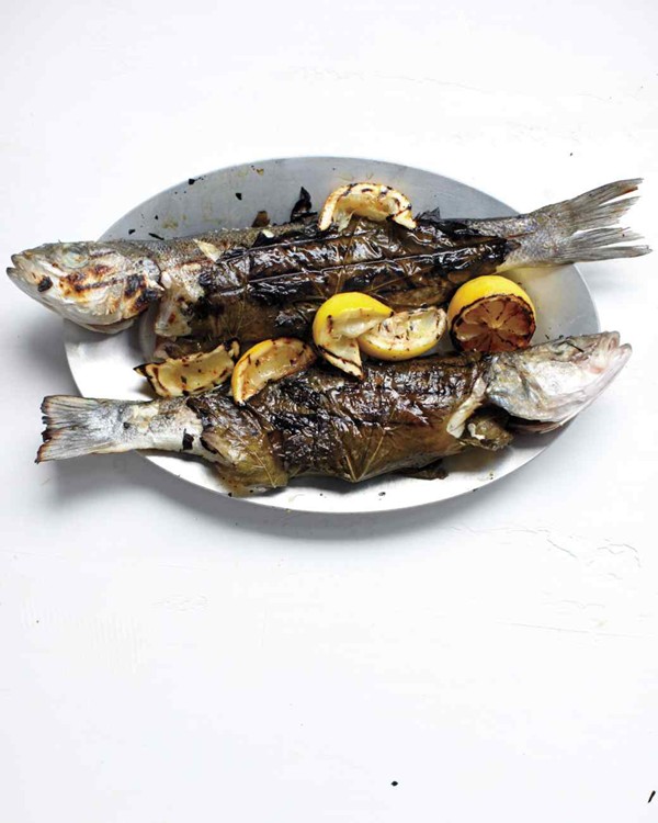 Whole branzino in grape leaves with zucchini, olives, and mint