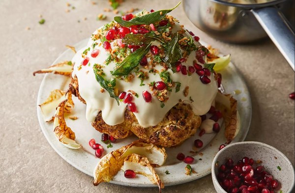 Whole cauliflower cheese with crispy onions, herbs & pomegranate