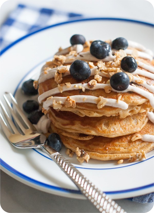 Whole wheat blueberry pancakes with healthy grain clusters and a cinnamon Greek yogurt drizzle