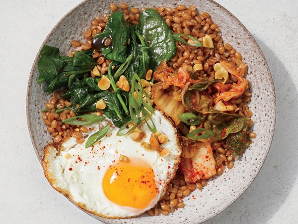 Wilted spinach and fried egg wheat berry bowl