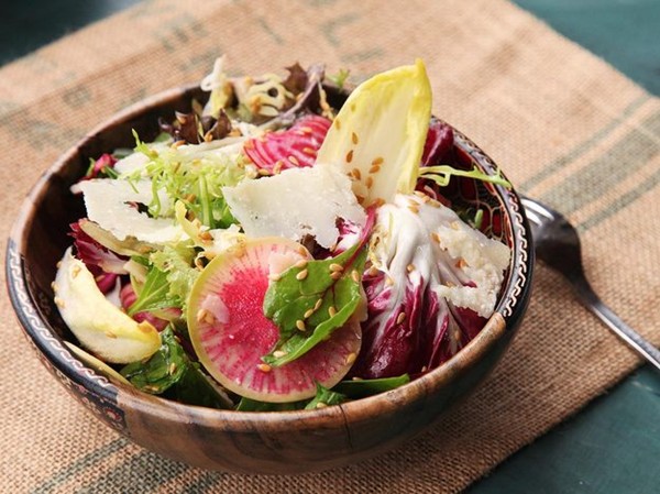 Winter greens salad with flax seeds, shaved beets, and radishes