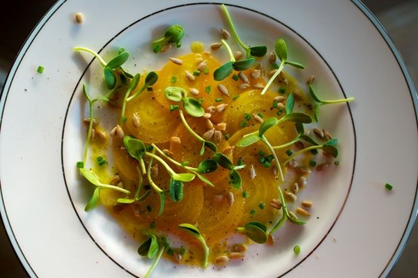 Yellow beet carpaccio with sunflower sprouts
